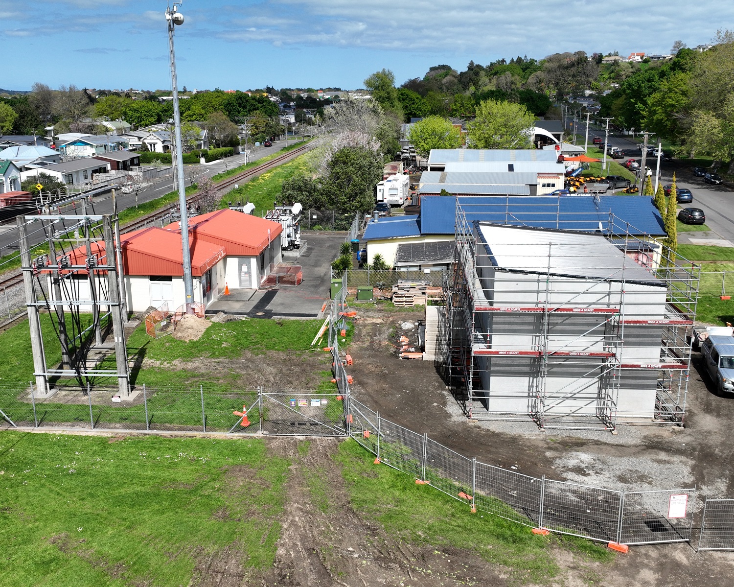 An aerial view of an electrical substation with two buildings - one is higher off the ground with scaffolding around it